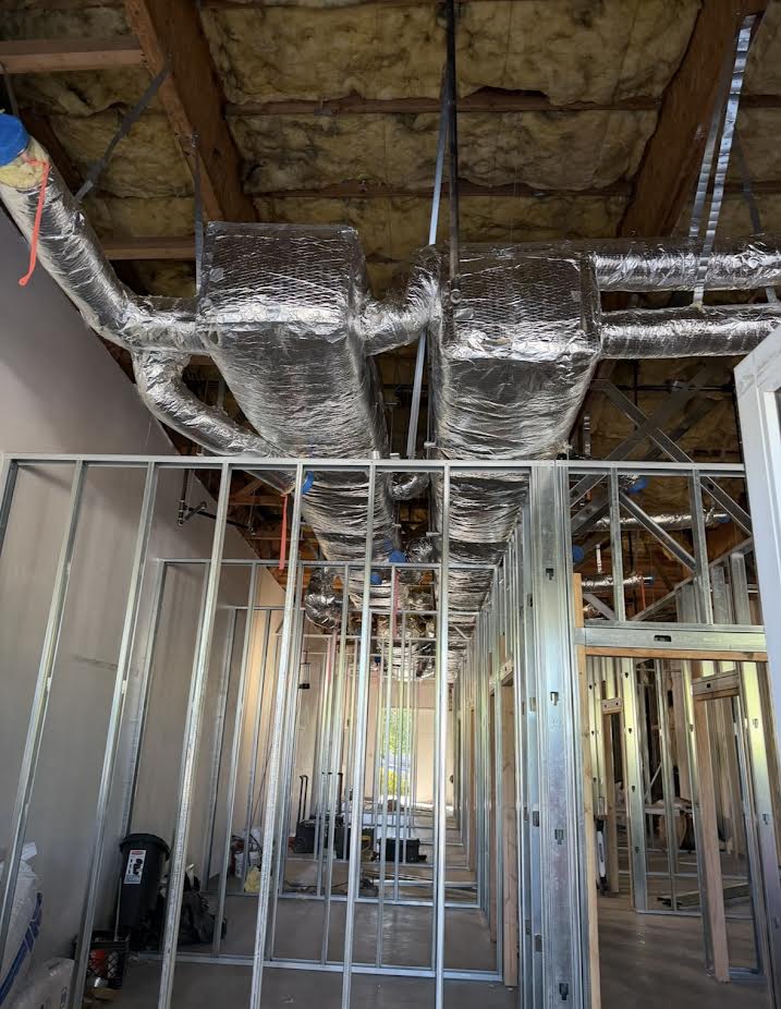Insulated overhead ductwork installed above interior framing